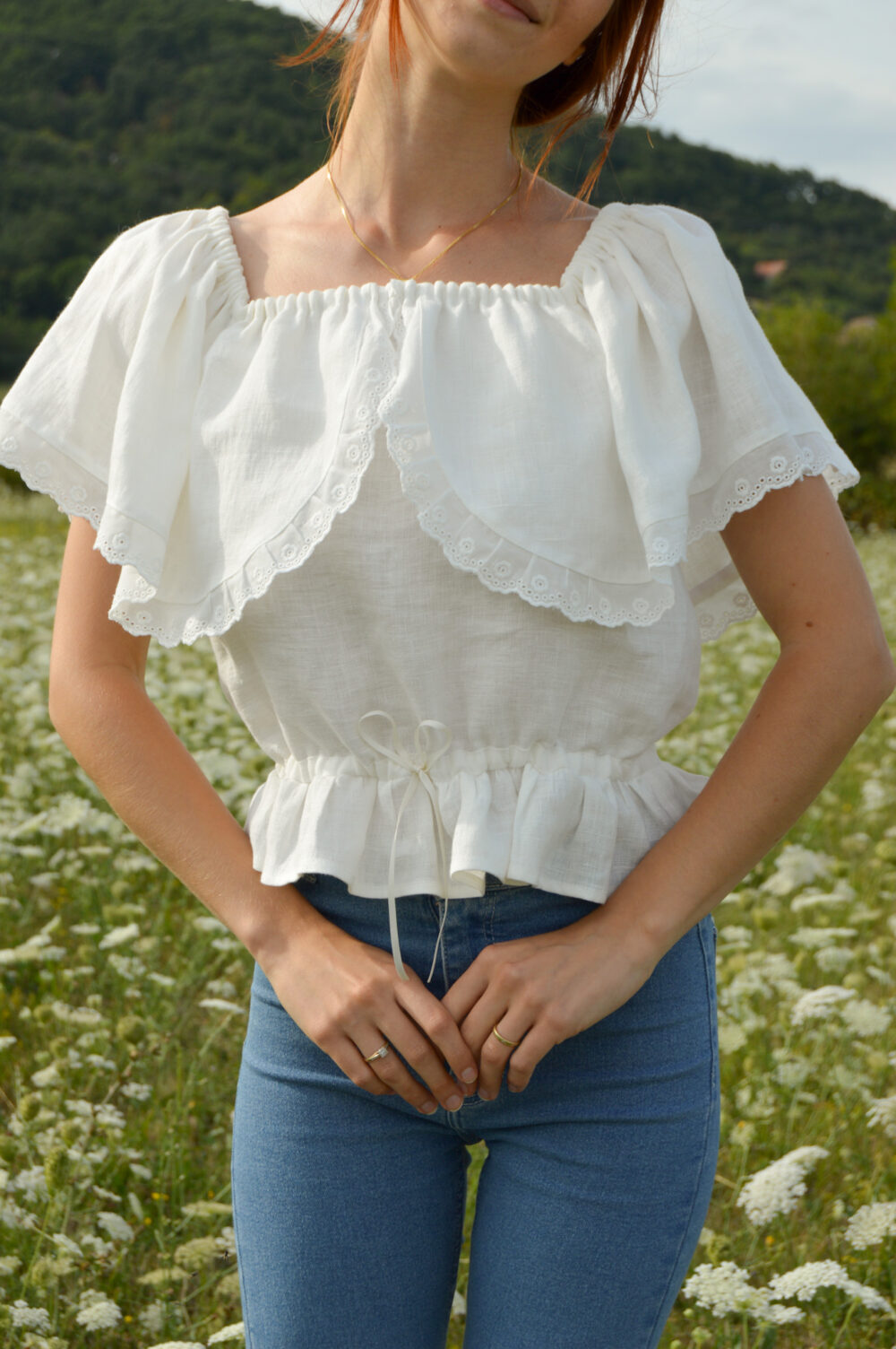 Magnolia top in ivory slovakmeadows Off-shoulder linen top with a romantic flounce, delicate lace trim, and an adjustable waist tie.