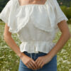 Magnolia top in ivory slovakmeadows Off-shoulder linen top with a romantic flounce, delicate lace trim, and an adjustable waist tie.