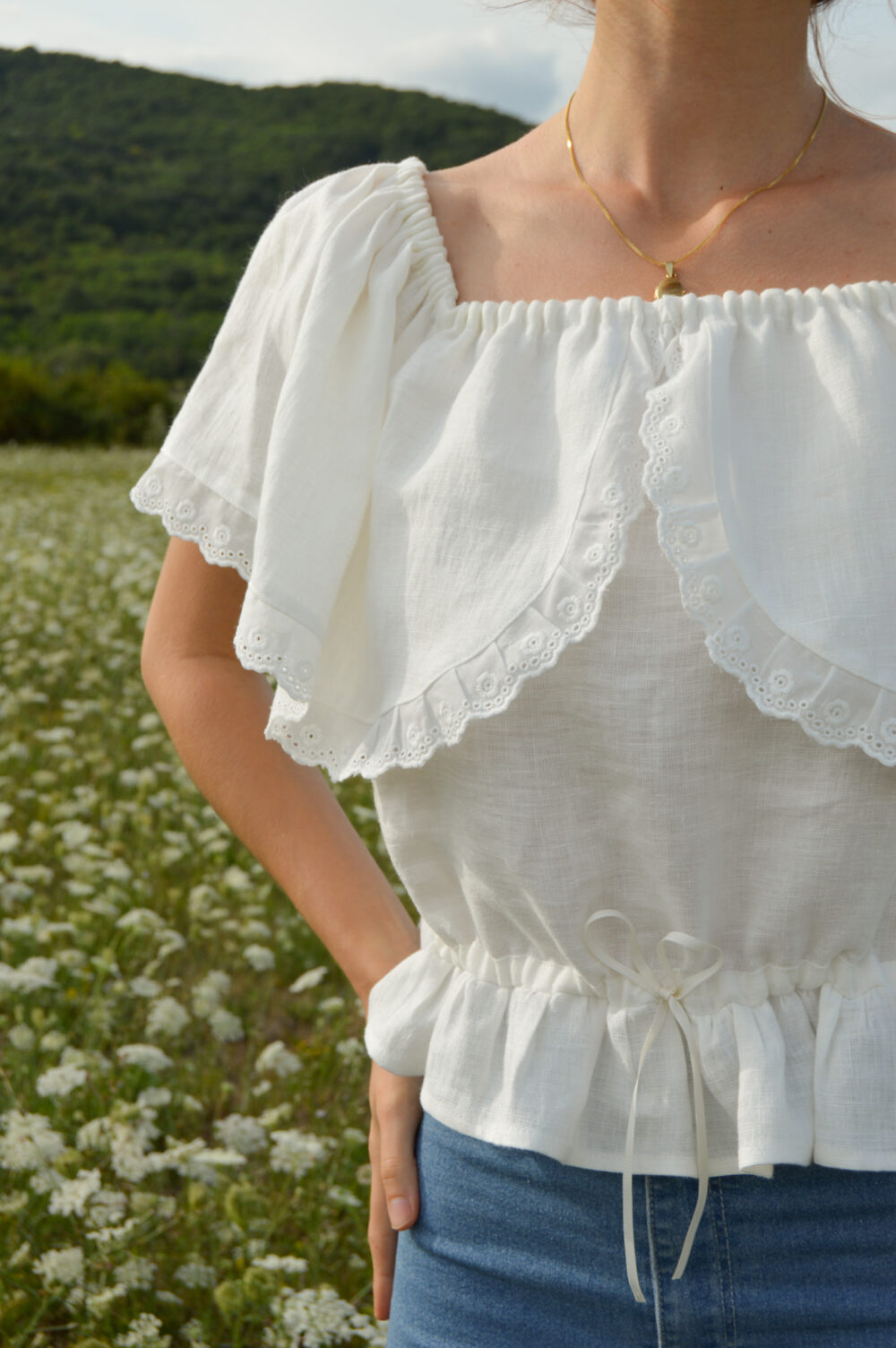 Magnolia top in ivory slovakmeadows Off-shoulder linen top with a romantic flounce, delicate lace trim, and an adjustable waist tie.